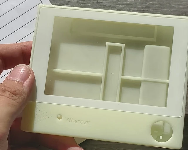 An early unpainted Wherezit enclosure shell, photographed on the bench.